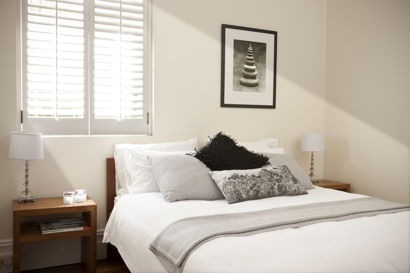 bedroom with light through window coming through the shutters.